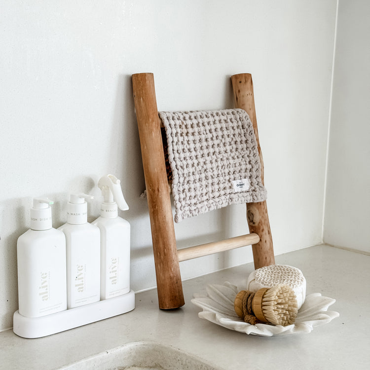 Natural timber decorative ladder leaning against wall